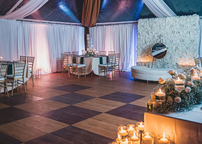 a dining table set up under a wedding tent